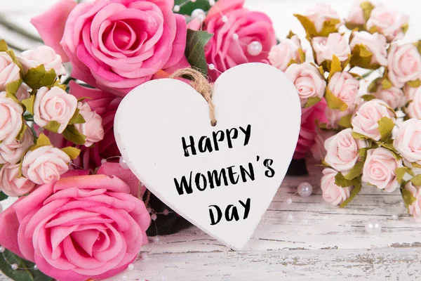 バレンタイン、母または女性の日のための花の組成。古い白い木の背景に木製の囲炉裏のピンクの花. — ストック写真