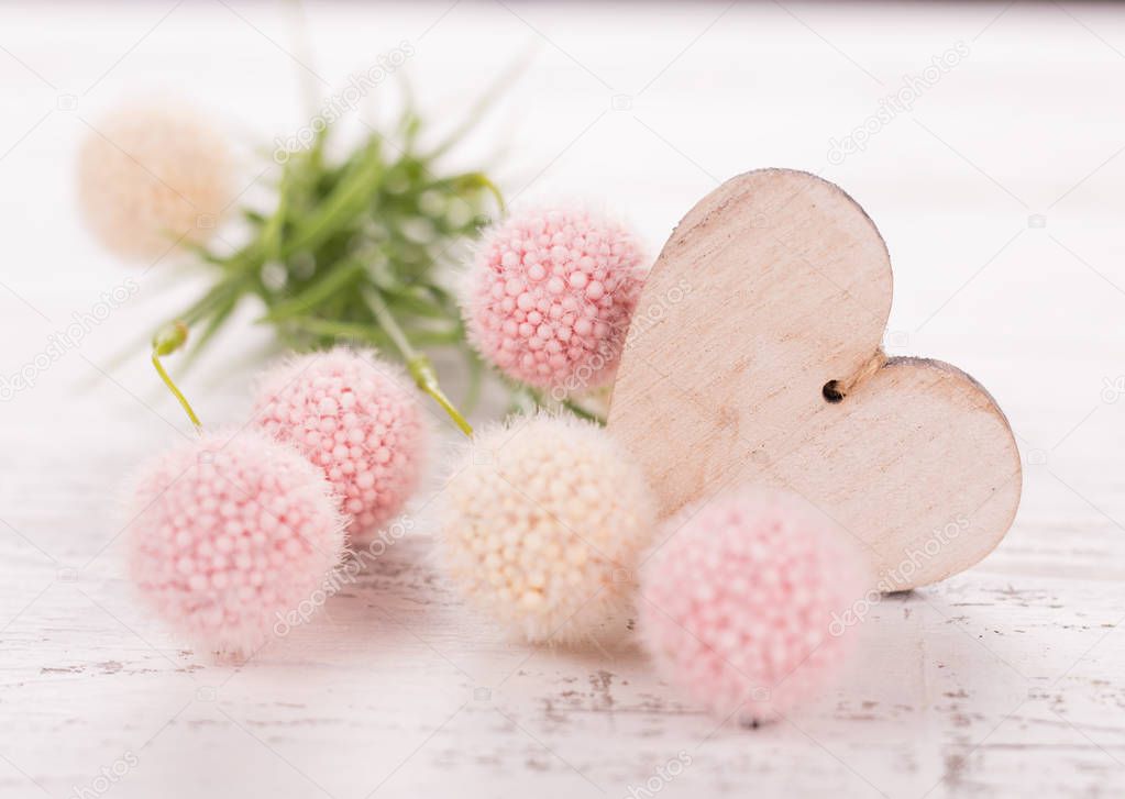 Flowers composition for Valentines, Mothers or Womens Day. Pink flowers with wooden hearth on old white wooden background.