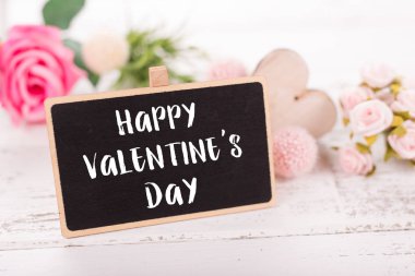 Sevgililer günü için küçük kara tahta. Arka plan ile pembe güller.