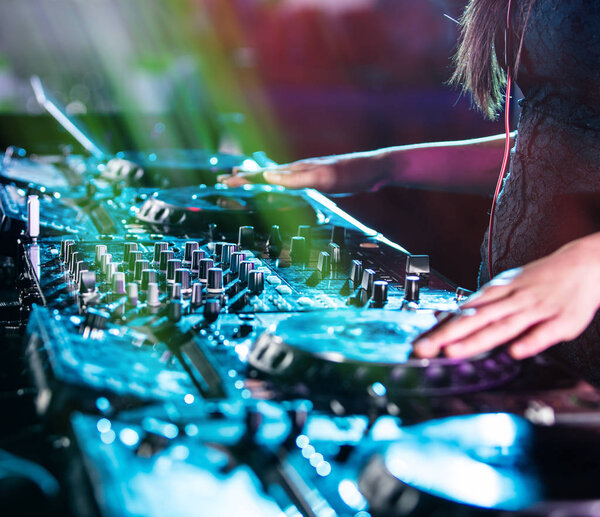 Dj mixes the track in the nightclub at a party