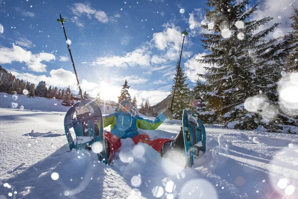 Glücklicher Schneeschuhwanderer im Pulverschnee mit schönen Sonnenstrahlen. — Stockfoto