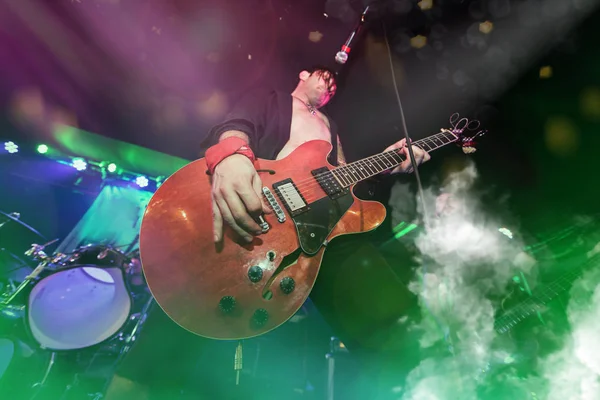 Um roqueiro está tocando guitarra no palco . — Fotografia de Stock