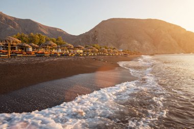 Gündoğumu sırasında Perissa kumsalda Yunan Adası Santorini.