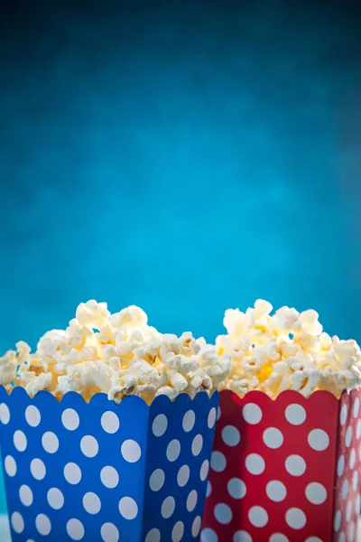 Dozen van popcorn op blauwe achtergrond. — Stockfoto