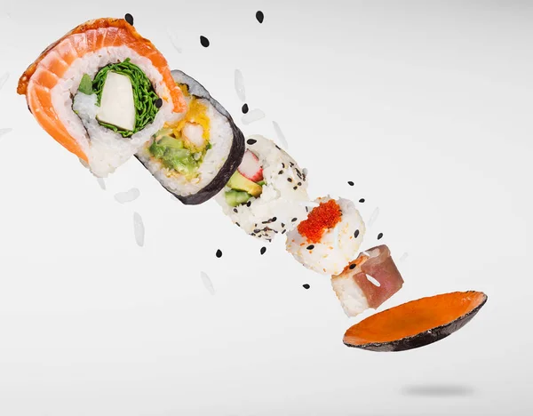 Pezzi di delizioso sushi giapponese congelato in aria. — Foto Stock