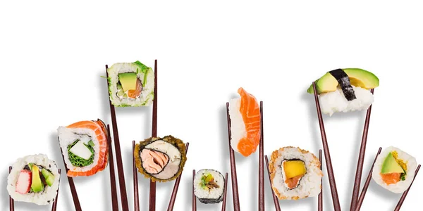 Geleneksel Japon suşi parçaları yemek çubuklarının arasına yerleştirilmiş, beyaz arka planda ayrılmış.. — Stok fotoğraf