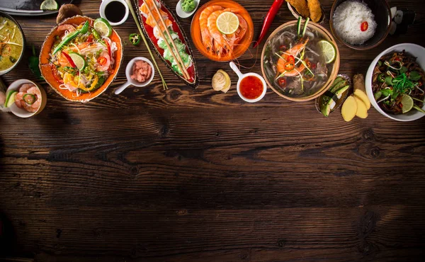 Különböző ázsiai ételeket a rusztikus háttér, felülnézet, hely a szöveg. — Stock Fotó