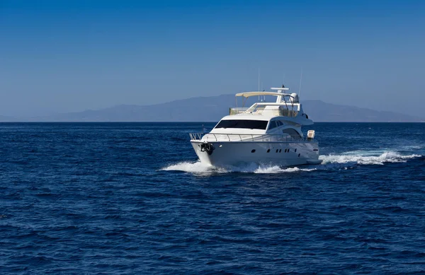 Boot in diepblauwe water, Santorini, Griekenland. — Stockfoto