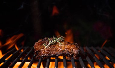 Beef steaks on the grill with flames clipart