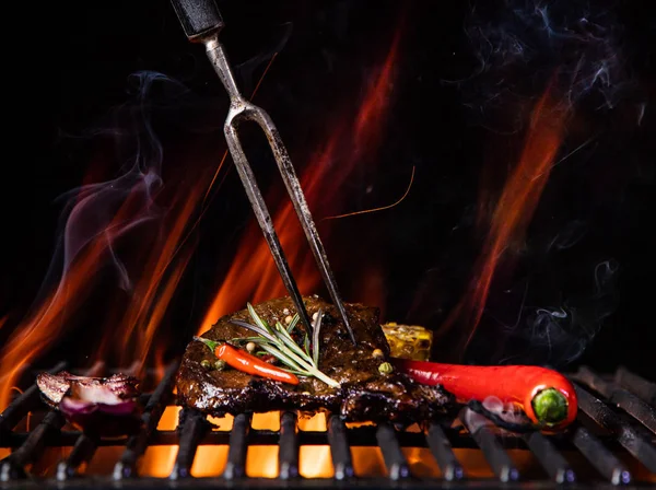 Steaks de boeuf sur le gril avec des flammes — Photo