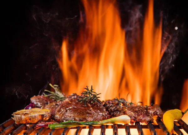 Steaks de boeuf sur le gril avec des flammes — Photo