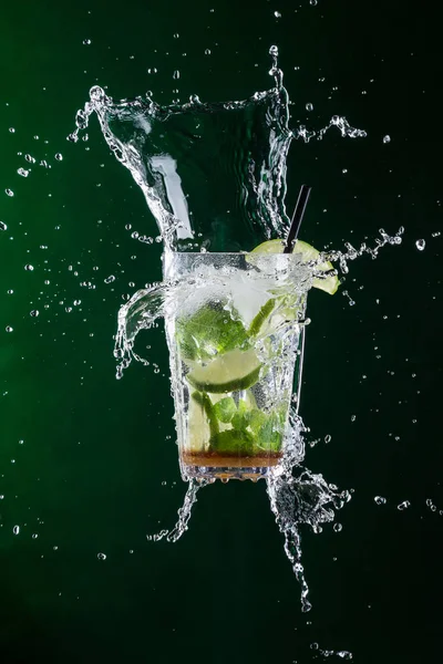Fresh mojito drink with liquid splash and crushed ice in freeze motion. — Stock Photo, Image