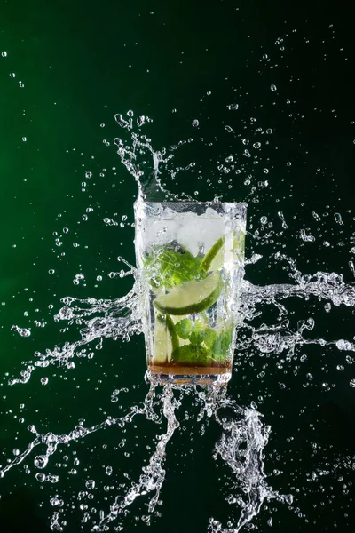 Fresh mojito drink with liquid splash and crushed ice in freeze motion. — Stock Photo, Image