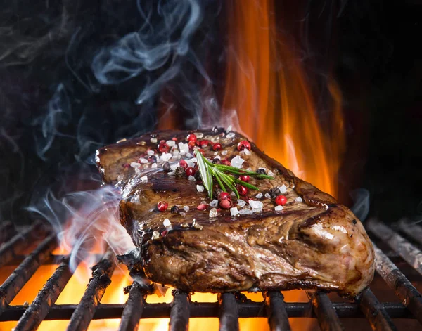 Rindersteak auf dem Grill mit Flammen — Stockfoto