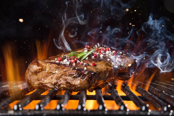 불길 이 분쇄기에 붙어 있는 쇠고기 스테이크 — 스톡 사진