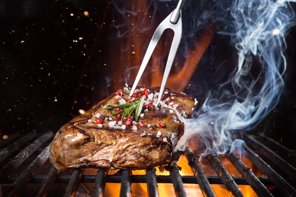 Biefstuk op de grill met vlammen — Stockfoto