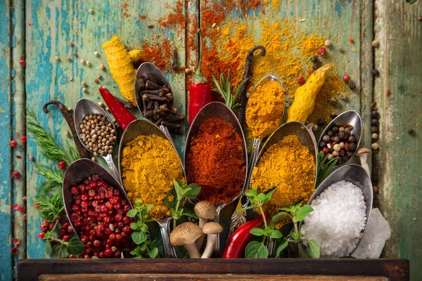 Diverse kleurrijke specerijen op houten tafel — Stockfoto