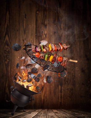 Su ısıtıcısı ızgara sıcak briketler, dökme demir ızgara ve lezzetli şişleri havada uçan.