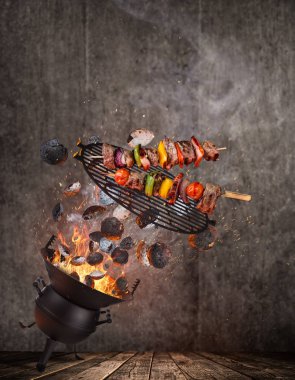 Su ısıtıcısı ızgara sıcak briketler, dökme demir ızgara ve lezzetli şişleri havada uçan.