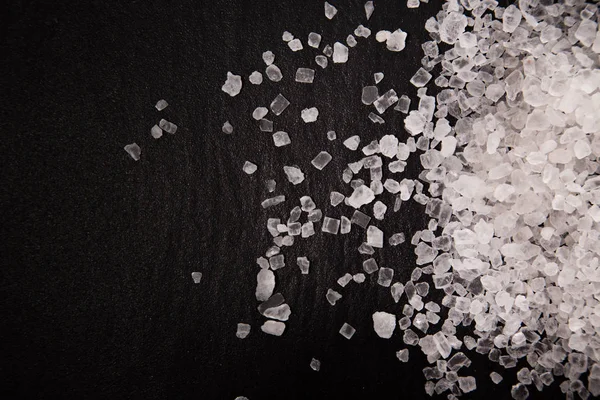 Diamante branco montão de sal de grão grosso no fundo de pedra preta . — Fotografia de Stock