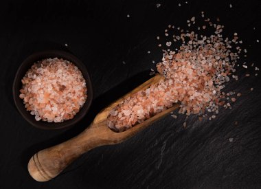 Pembe Himalaya kaba tahıl tuz siyah taş zemin üzerine.