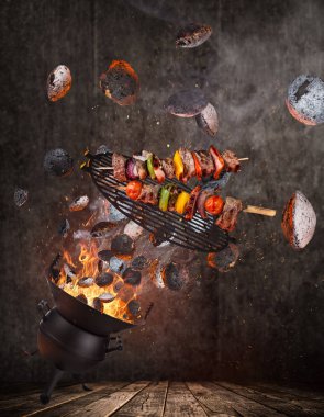 Su ısıtıcısı ızgara sıcak briketler, dökme demir ızgara ve lezzetli şişleri havada uçan.