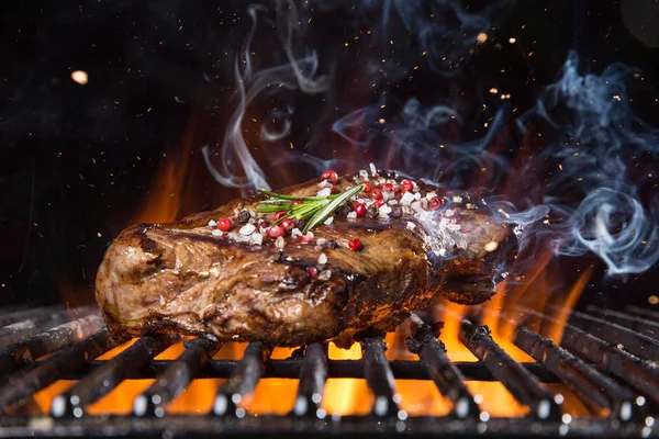 Rindersteak auf dem Grill mit Flammen — Stockfoto