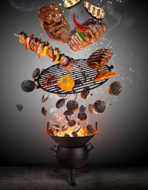 Su ısıtıcısı ızgara sıcak briketler, dökme demir ızgara ve lezzetli etler havada uçan.