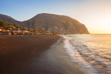 Gündoğumu sırasında Perissa kumsalda Yunan Adası Santorini.