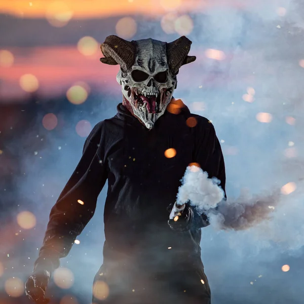 Guy in devil mask standing with smoke bombs — Stock Photo, Image