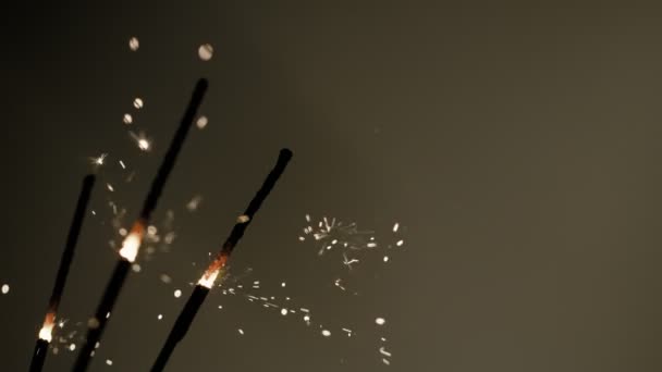 Burning sparklers on dark golden background. Super Slow Motion. — стокове відео