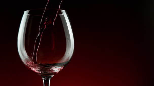 Super Slow Motion Detail Shot of Pouring Red Wine from Bottle on dark Background.