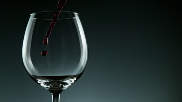 어두운 배경에 있는 병에서 나오는 레드 와인을 끓이는 슈퍼 슬로우 모션 디테일 샷. — 비디오
