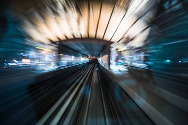 Tran bir gece şehrinde raylarda koşuyor..