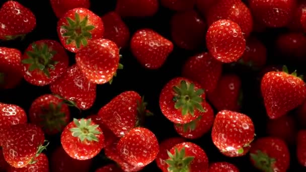 Explodierende Erdbeeren auf schwarzem Hintergrund. — Stockvideo