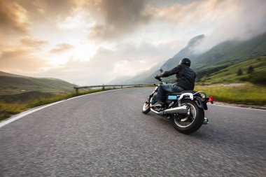 Motorcycle driver riding in Dolomite pass, Italy, Europe. clipart