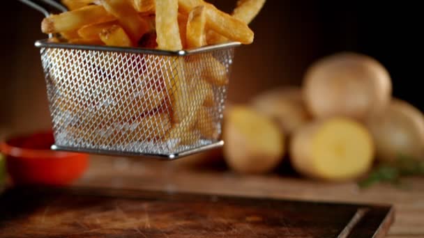 Super Slow Motion Colpo di caduta patatine fritte fresche sul tavolo di legno — Video Stock