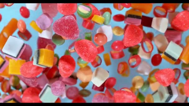 Sweet candies flying in slow motion against pastel background. Filmed on high speed cinema camera — Stock Video