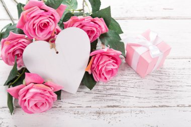 Sevgililer Günü, Anneler ya da Kadınlar Günü için çiçek kompozisyonu. Eski beyaz ahşap arka planda tahta ocağı olan pembe çiçekler..