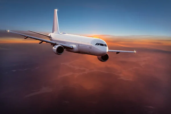 Avión comercial jetliner volando por encima de nubes dramáticas. — Foto de Stock