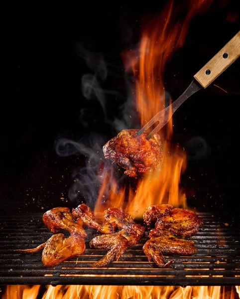 Csirke lábak és a szárnyak a lángok grill — Stock Fotó