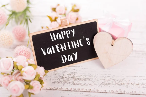 Sevgililer günü için küçük kara tahta. Arka plan ile pembe güller.