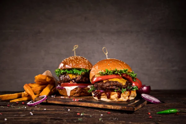 Sabrosas hamburguesas sobre mesa de madera. — Foto de Stock
