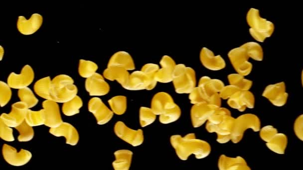 Super slow motion van vliegende ongekookte Italiaanse pasta op zwarte achtergrond. — Stockvideo