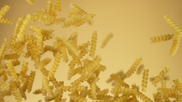 Super slow motion di pasta italiana cruda volante su sfondo dorato. — Video Stock