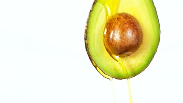 Свежевырезанный авокадо с нефтяным потоком. Концепция здоровых фруктов также полезна в косметике. — стоковое видео