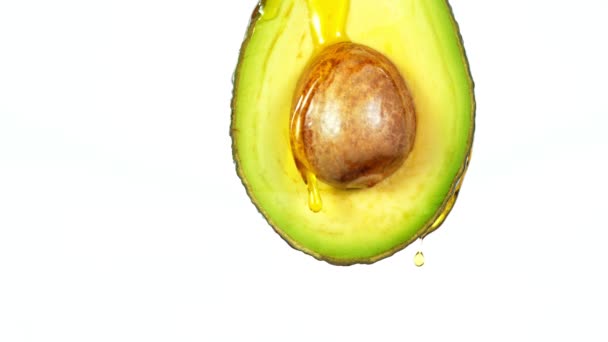 Frisch geschnittene Avocado mit Ölstrom. Konzept von gesundem Obst auch in der Kosmetik nützlich. — Stockvideo