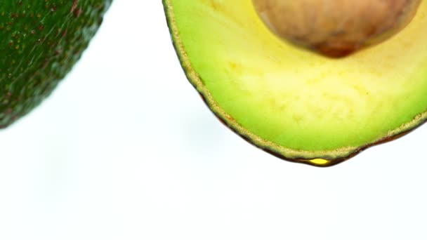 Čerstvě nakrájené avokádo s proudem oleje. Koncept zdravého ovoce užitečný i v kosmetice. — Stock video