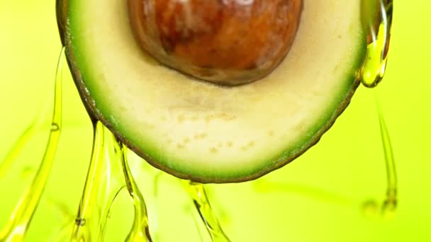 Свежевырезанный авокадо с нефтяным потоком. Концепция здоровых фруктов также полезна в косметике. — стоковое видео