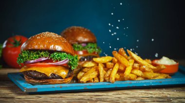 Patates kızartması çizburgerin yanına düşer, eski ahşap kesim tahtasının üzerine uzanır..